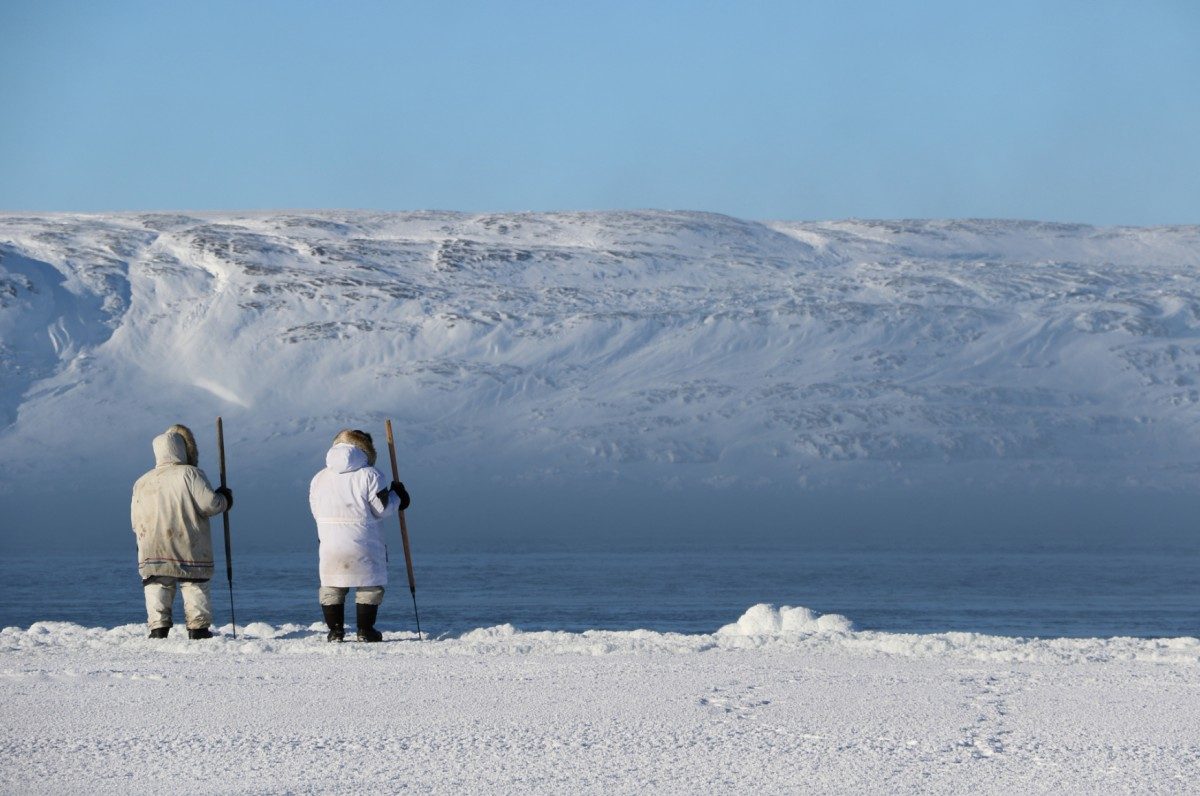 An Inuit hunters walks on sea ice