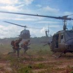 Soldiers in Vietnam run to a helicopter