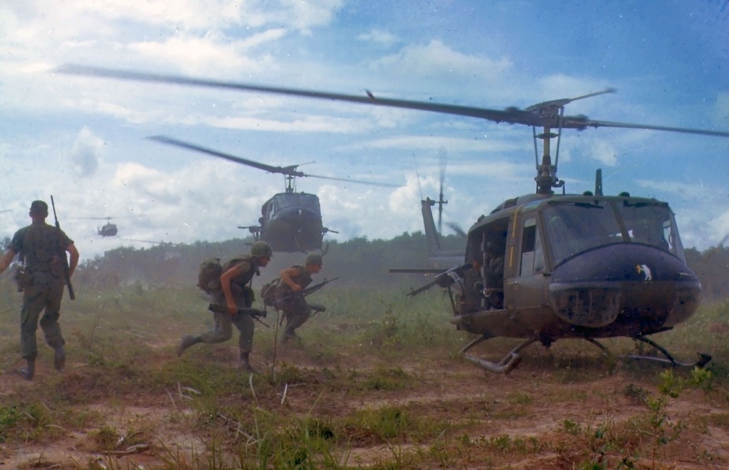 Soldiers in Vietnam run to a helicopter