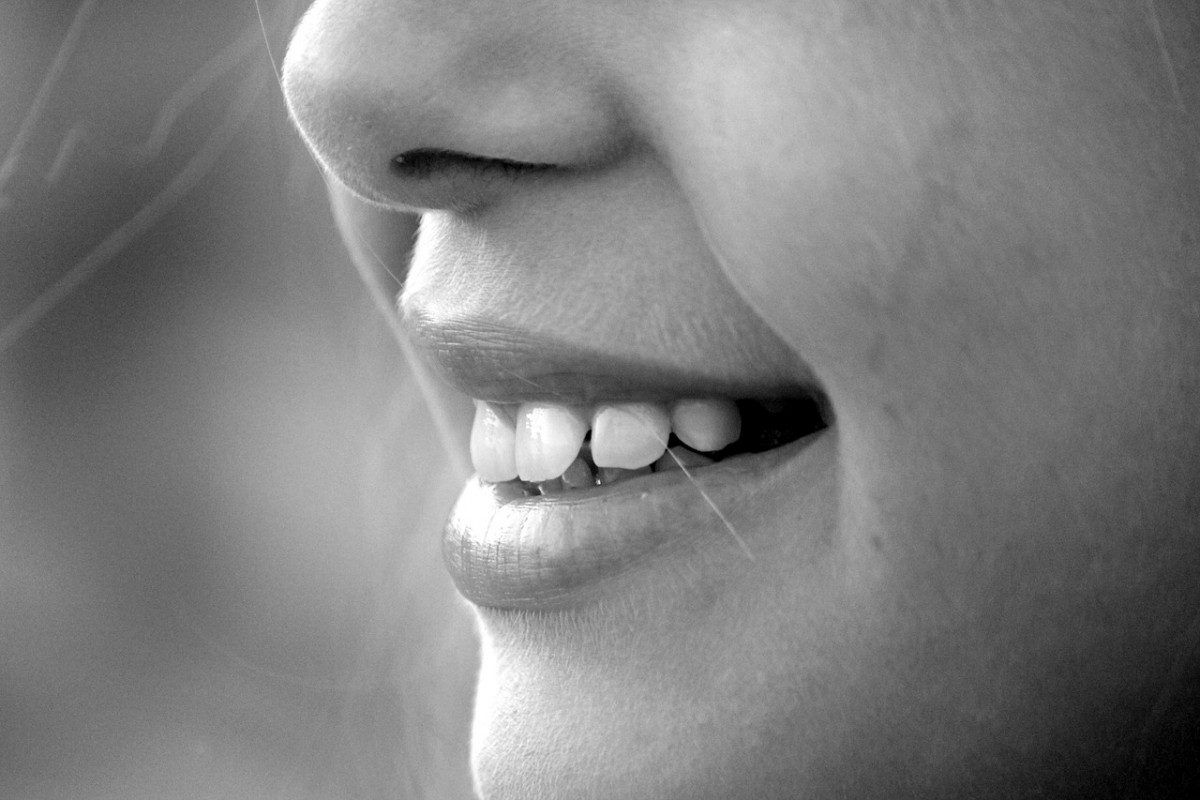 a balck and white image of a child's smile