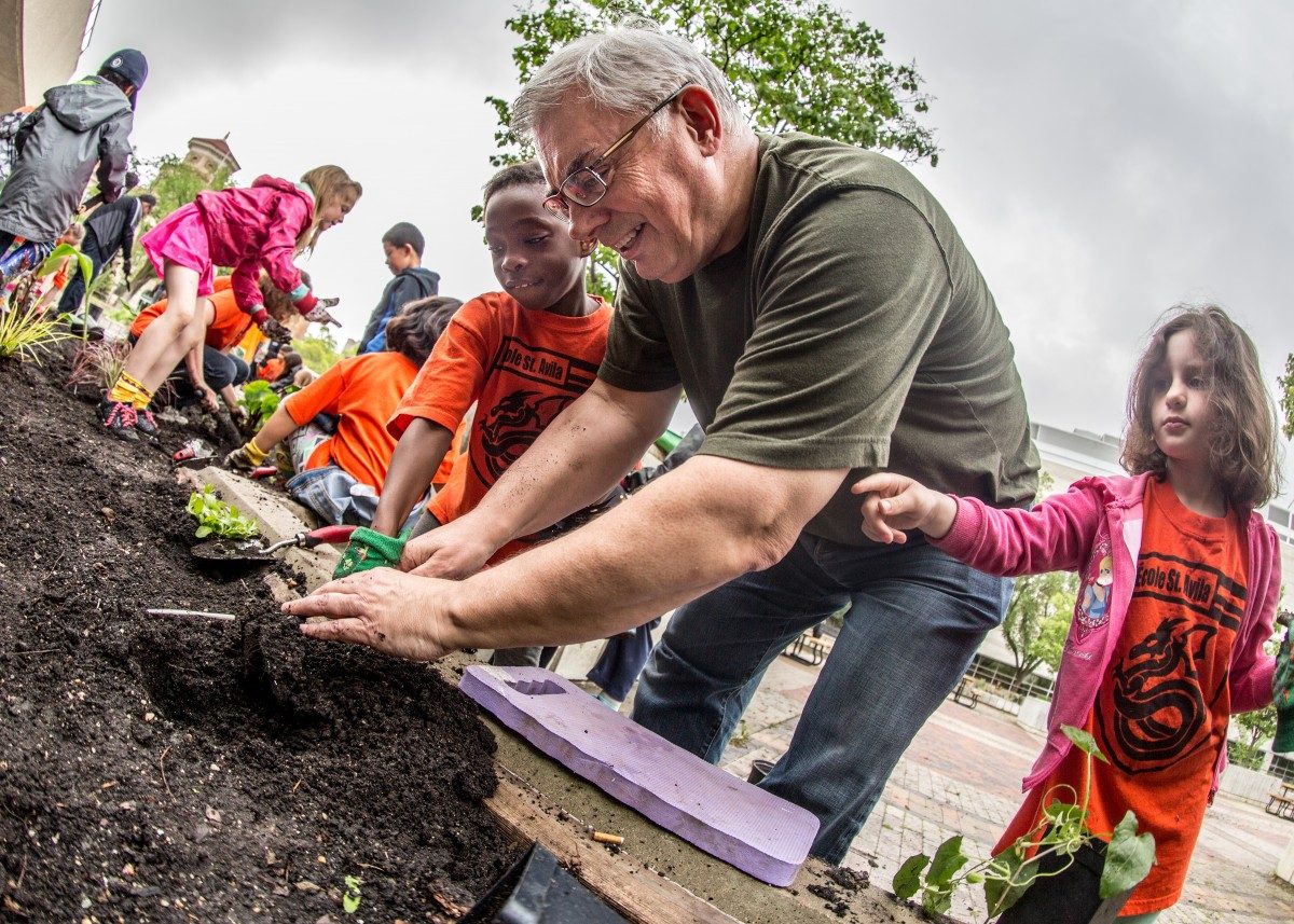 President and Vice-Chancellor David Barnard planting with students from École St. Avila at the 2016 Campus Beautification Day