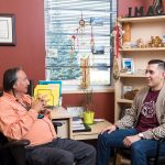 Noah Wilson sits with Carl Stone, student advisor at the Indigenous Student Centre in Migizii Agamik – Bald Eagle Lodge.