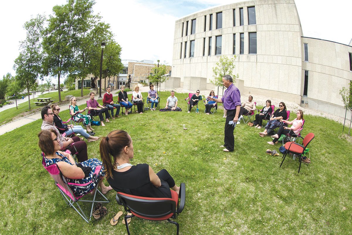 DURING LIVE WELL @ WORK WEEK THIS PAST JUNE, FACULTY AND STAFF ATTEND A MEDICINE WHEEL TEACHINGS WORKSHOP LED BY UNIVERSITY ELDER-IN-RESIDENCE NORMAN MEADE OUTSIDE MIGIZII AGAMIK - BALD EAGLE LODGE.