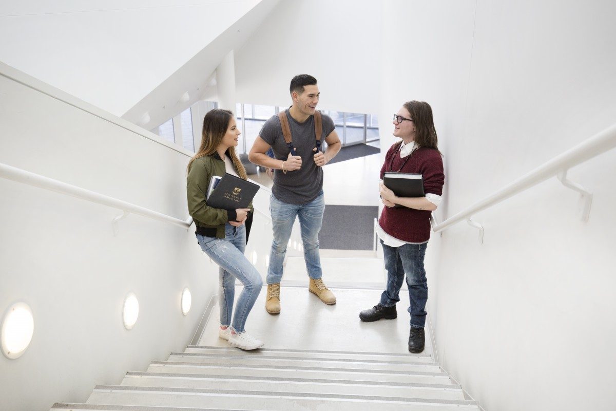 Three Indigenous students on the stairs of ARTlab