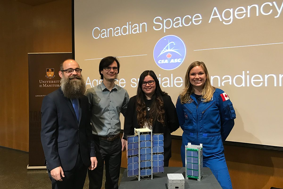 Dr. Philip Ferguson (mechanical engineering) and his graduate students Valorie Platero and Matthew Driedger, with CSA Astronaut Dr. Jenni Sidey, and a model of CubeSAT.