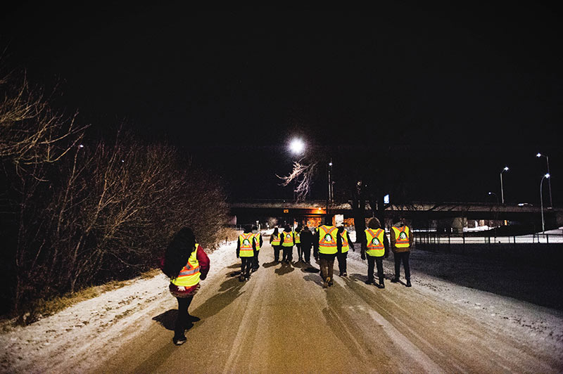 On this cold January night, there are 19 volunteers in high-vis safety vests hauling two wagons of food, water, toques, scarves and mitts to hand out in Winnipeg’s homeless hub.