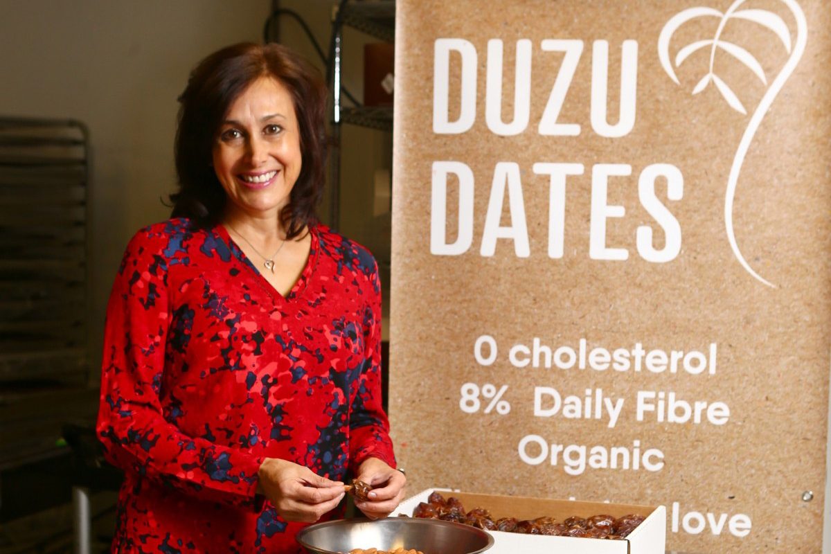 Lorena Prakash stuffs dates before they're coated with chocolate. // Photo by Jim Wells.