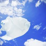 White plastic bag floating in blue sky.