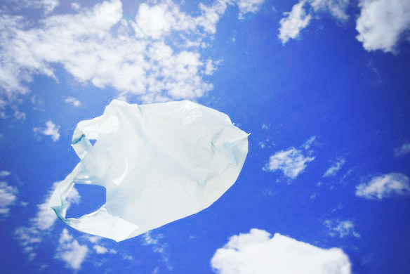 White plastic bag floating in blue sky.