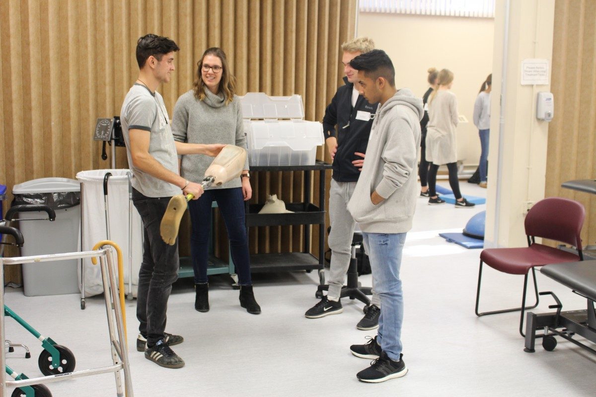 students interacting with a researcher in a lab