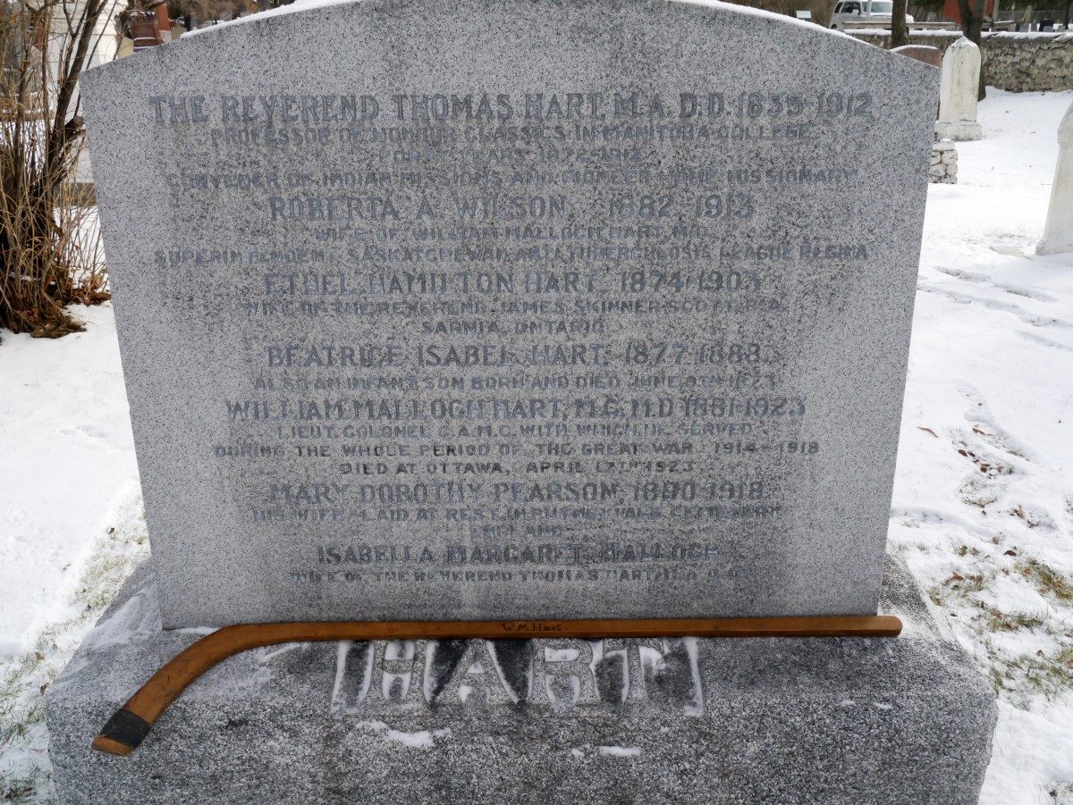 A hockey stick at the base of a headstone