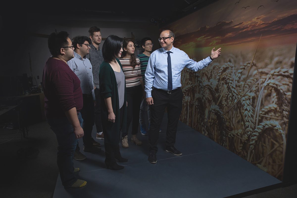 Pourang Irani (right) with students inspecting a spatio-temporal dataset on a large screen display.