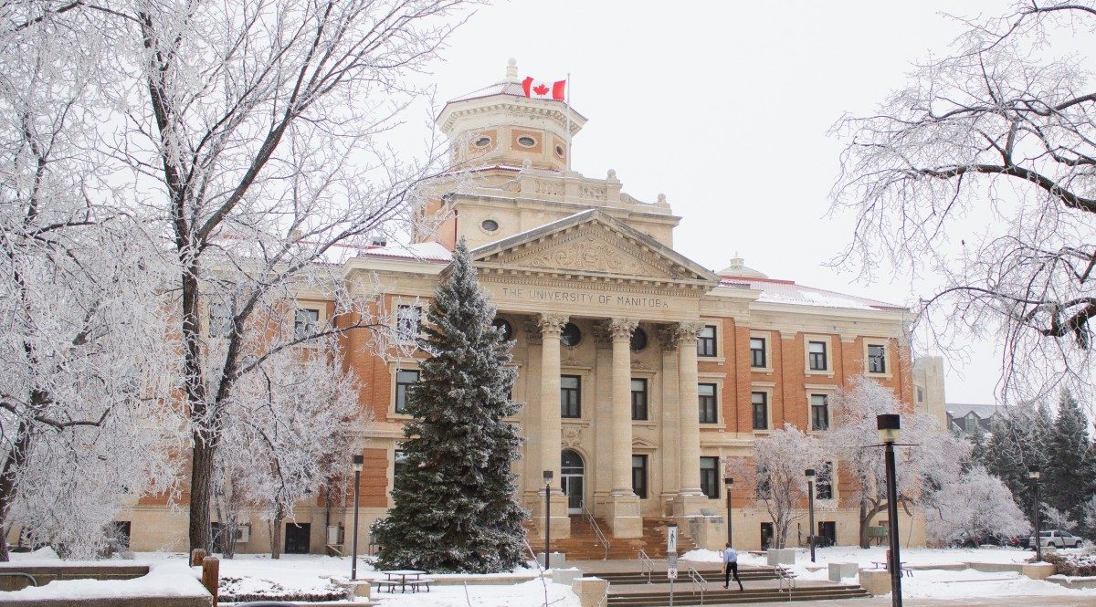 The U of M administration building flanked by snowy trees