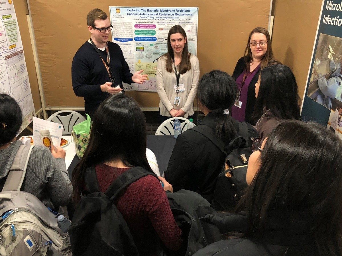 Students crowd around the Department of Medical Microbiology and Infectious Diseases booth at the Graduate Studies Open House.