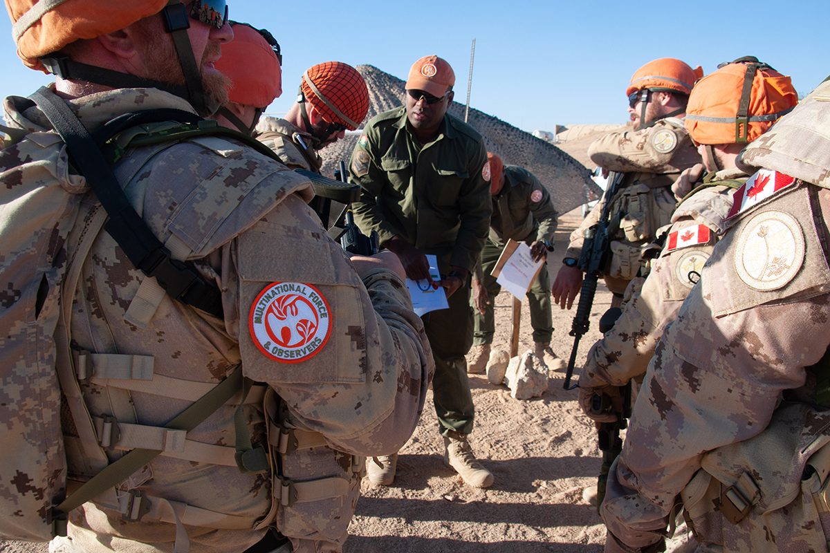 Canadian Armed Forces personnel being briefed by a Fijian colleague on a task they are to perform.