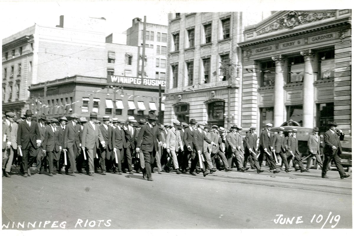 Special police marching west down Portage from Main Street during June 10, 2019 riot. // Winnipeg Tribune Photograph Collection at U of M Archives and Special Collections