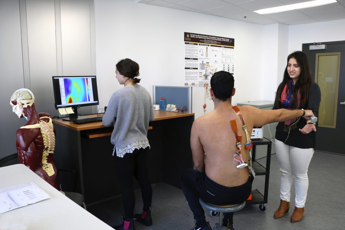 A person is strapped to a shoulder contraption analyzing movement in a research lab.