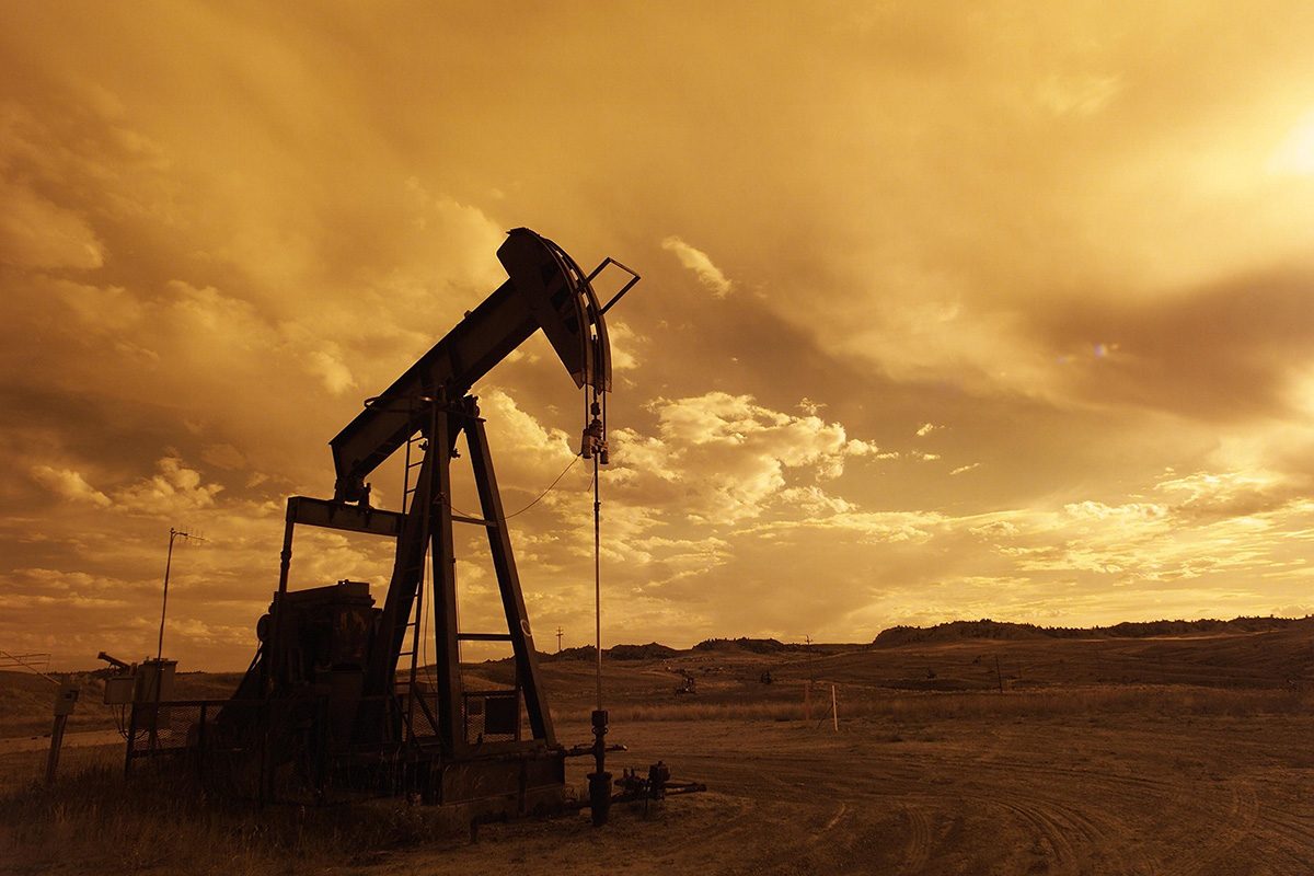 An oil pumpjack is shown in a field. // Image from Pixabay