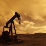 An oil pumpjack is shown in a field. // Image from Pixabay