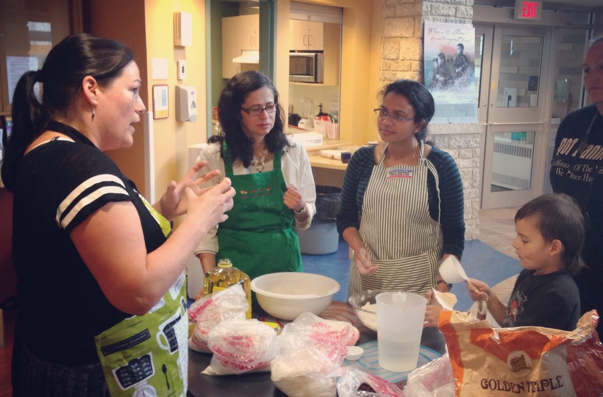 Instructor teaches students how to prepare food in Migizii Agamik.
