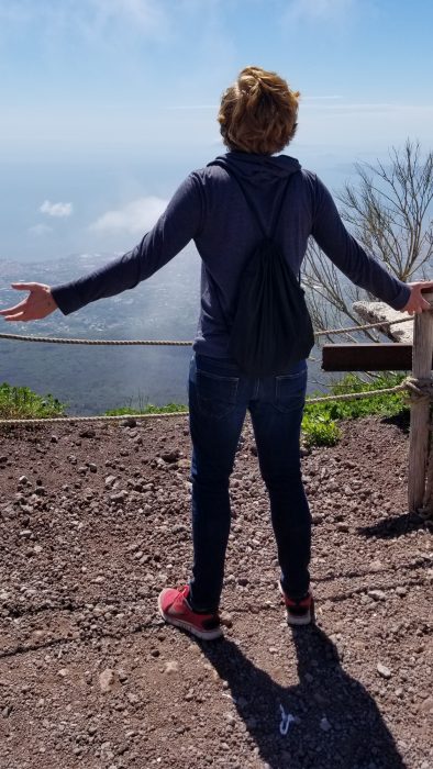 Timm Giessbrecht with arms outstretched on the peak of Mount Vesuvius