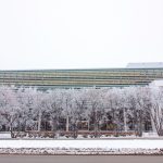 The exterior of the Active Living Centre. It's winter and there's frost and snow on a series of trees in front of the building.