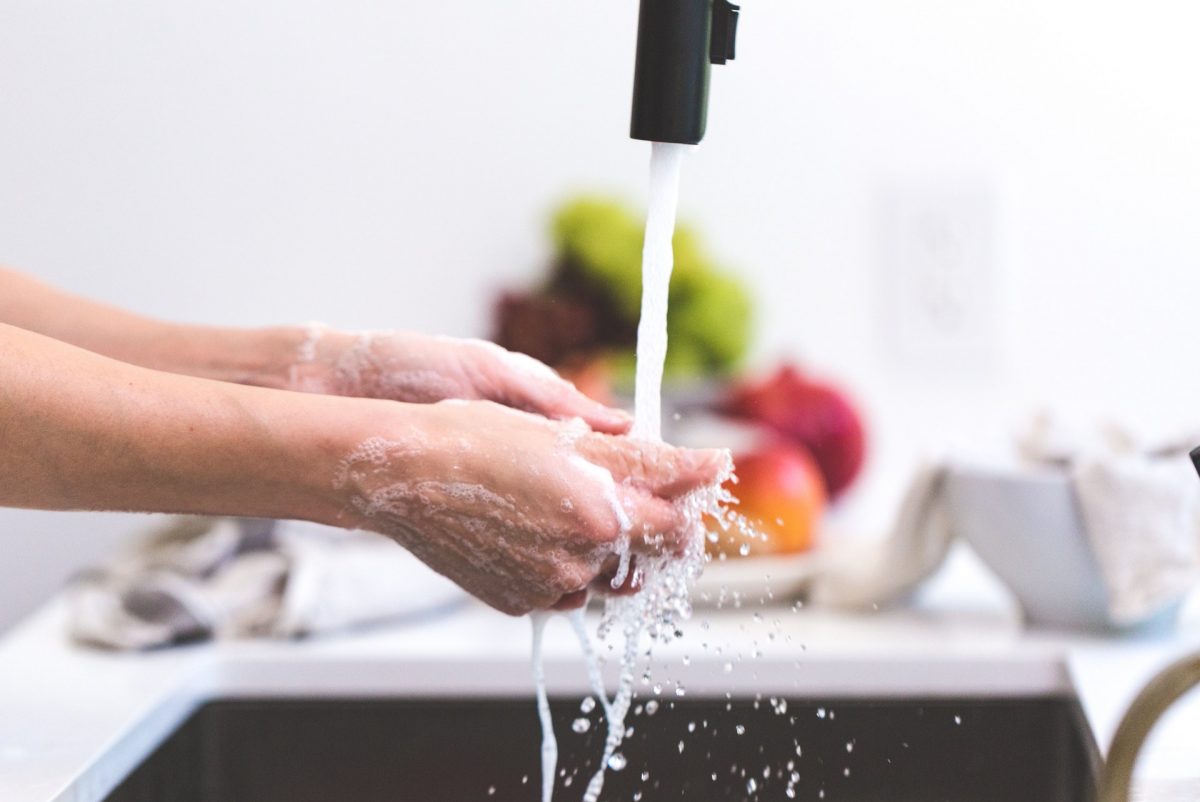 Person washing hands, food in background