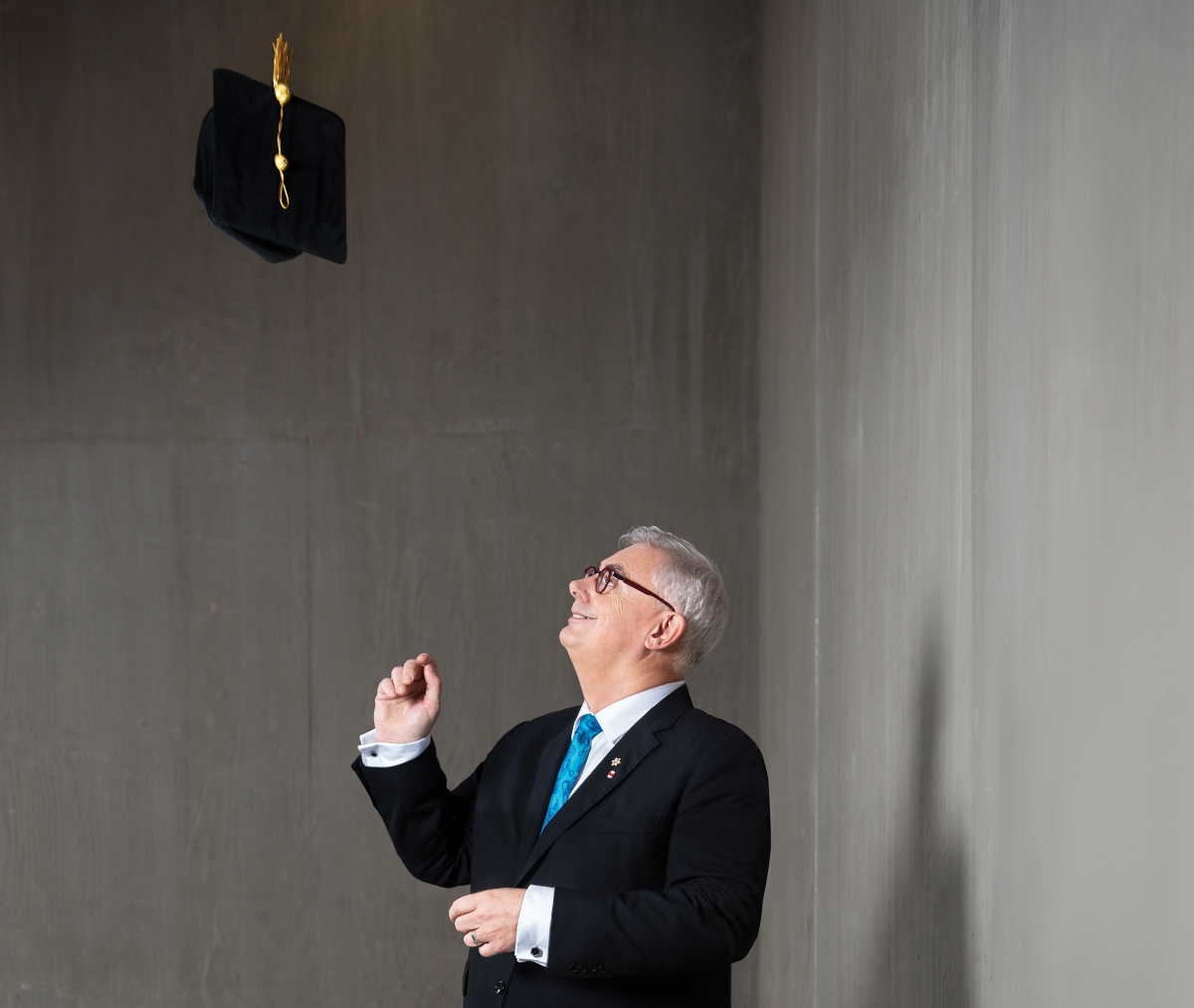 President Barnard throws a mortarboard in the air.