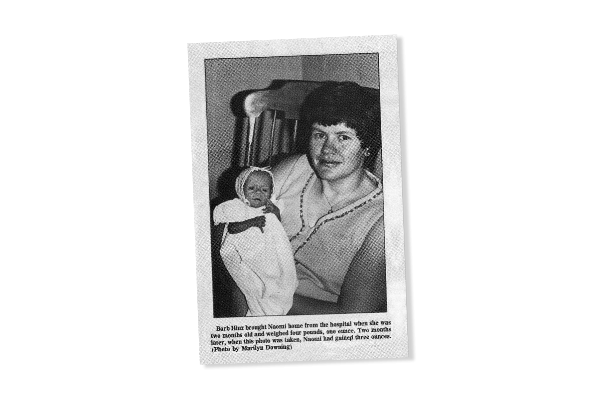 A woman holds an underweight baby in a vintage newspaper clipping.