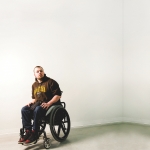 Andrew Fenwick sits in a wheelchair in an empty room.