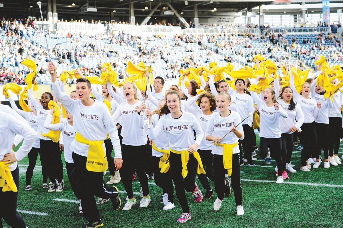 Students run on the field at the launch of the Front and Centre campaign.