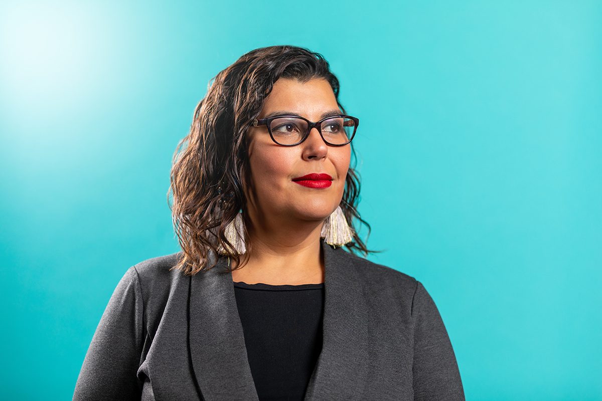 Dr. Marcia Anderson in front of a teal backdrop