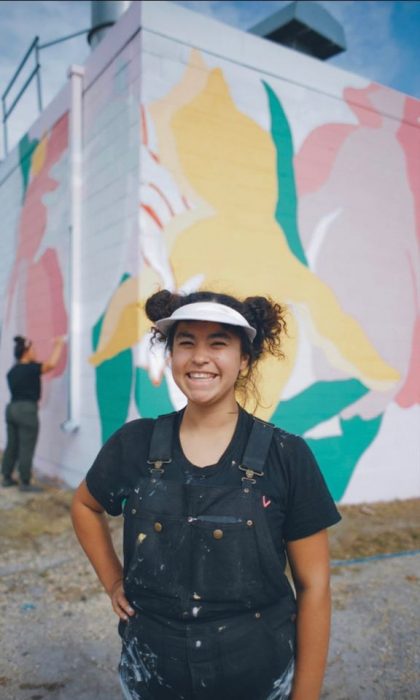 School of Art graduate and Artist Annie Beach in front of a painted mural.
