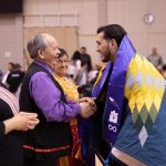 An Indigenous student shaking hands with an Elder at the 2019 Traditional Graduation Pow Wow