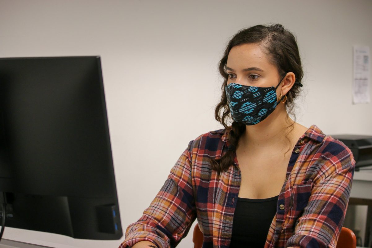 woman in mask at computer