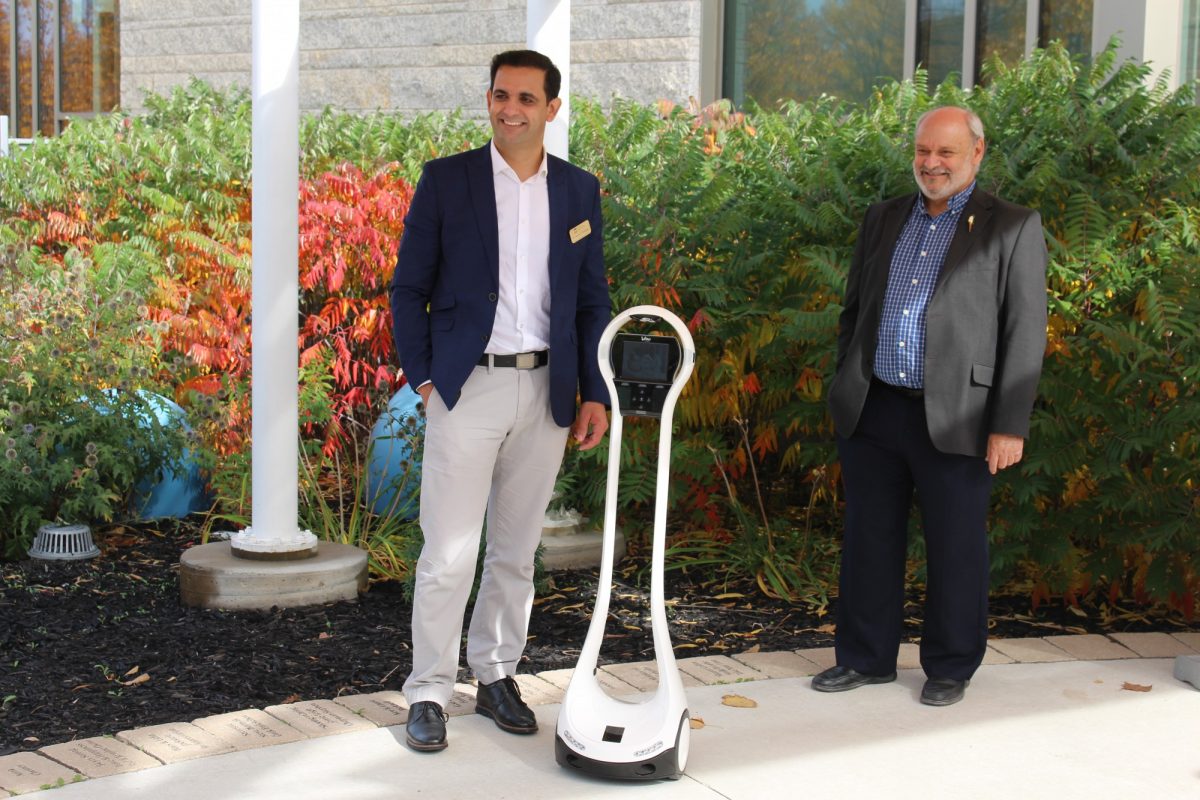 Researchers pose with telepresence robot