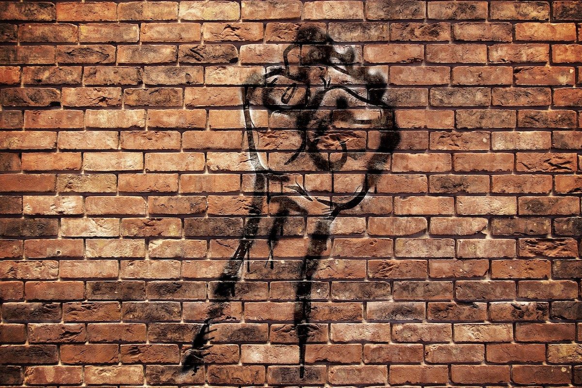 Protest fist art on brick wall.