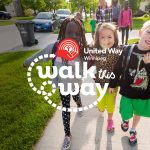 Three children walking arm in arm