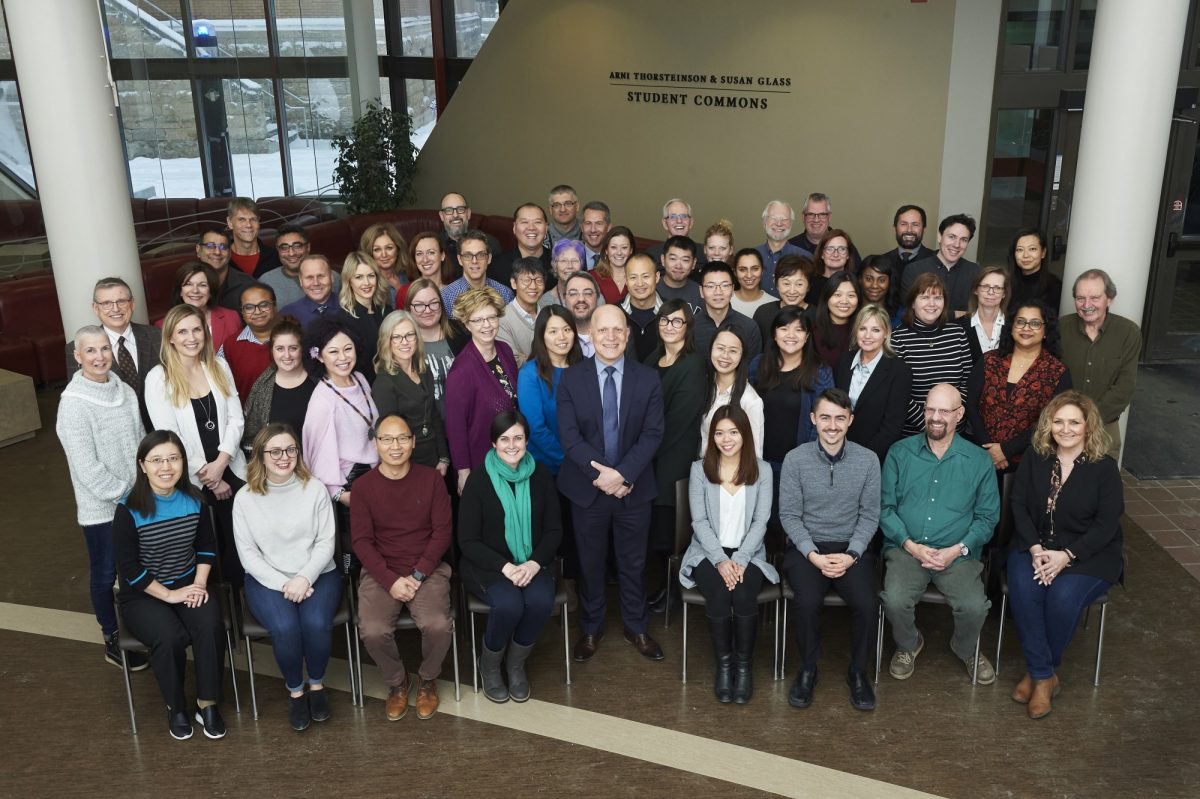 A group photo of more than 40 Asper School of Business. It is a diverse group of people and everyone is smiling.
