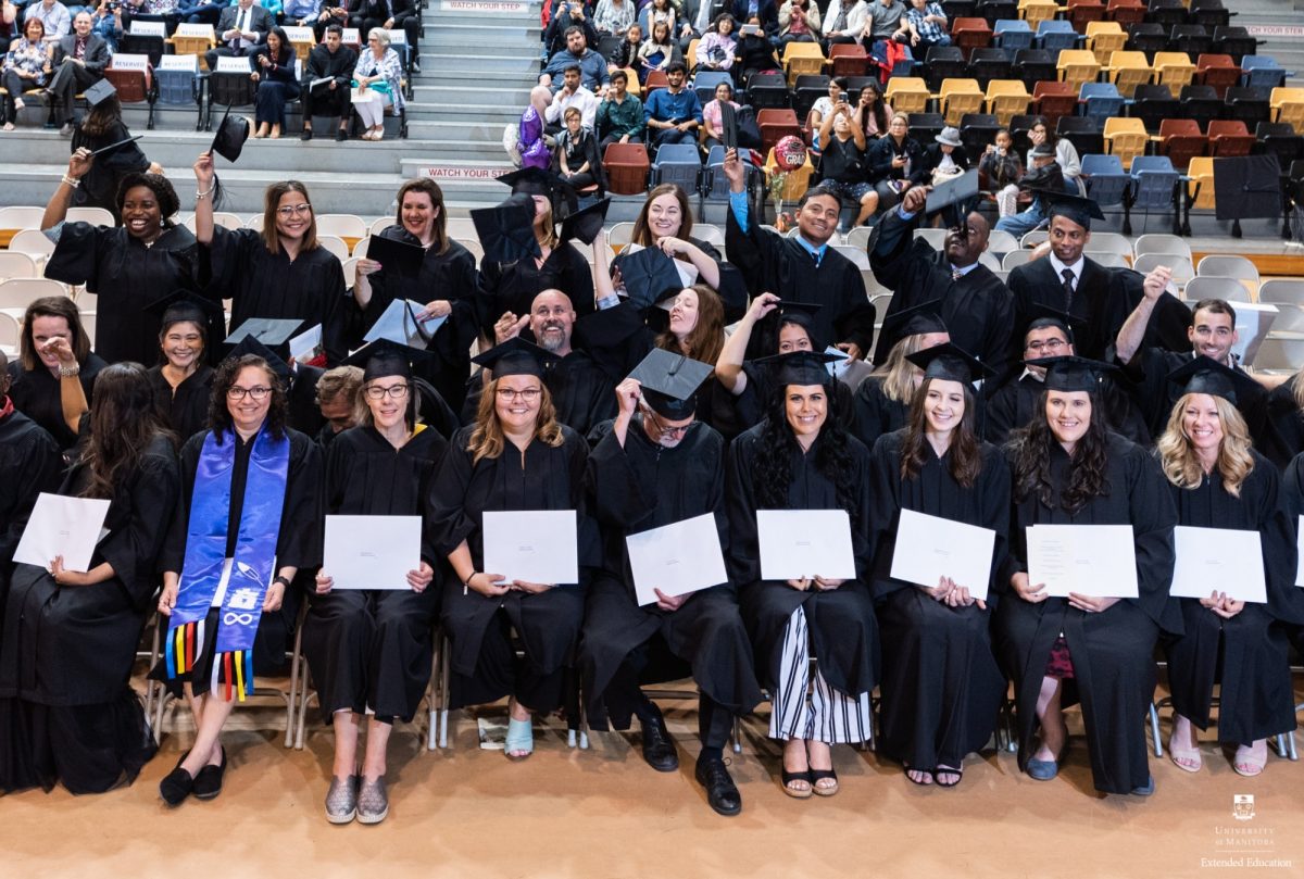 A group of graduates celebrates at a past graduation.