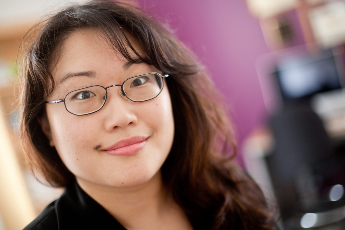 Headshot of Nancy Kang with blurred office background.