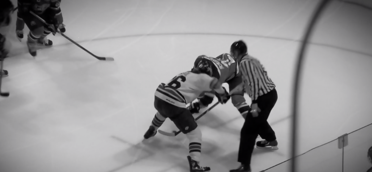 a faceoff during a hockey game. the image is black and white.