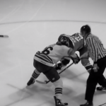 a faceoff during a hockey game. the image is black and white.