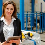 Woman working with a tablet on a factory floor.