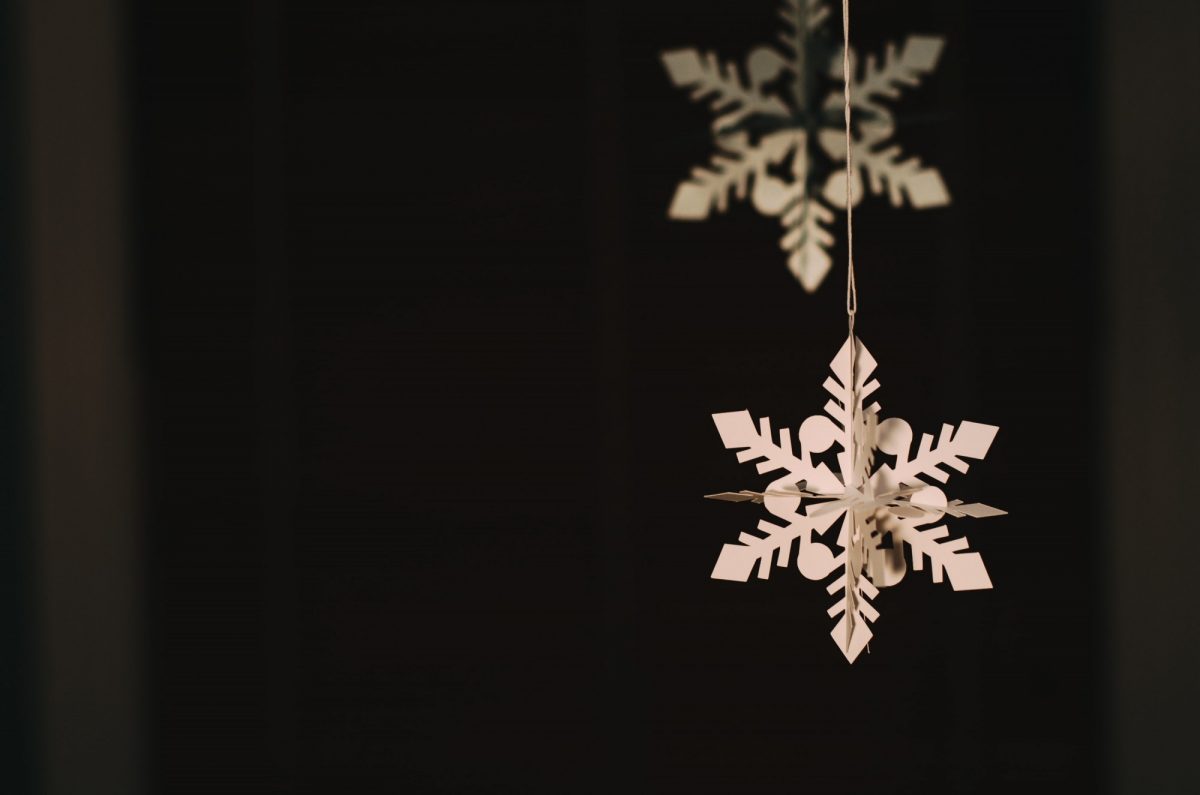 Paper snowflake hanging over a black background