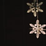 Paper snowflake hanging over a black background