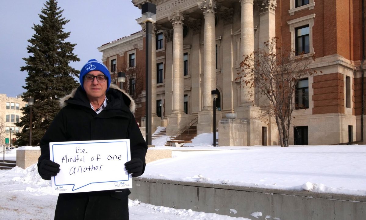 President Michael Benarroch holds a signs that asks us to be mindful of each other