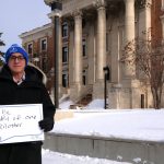 President Michael Benarroch holds a signs that asks us to be mindful of each other