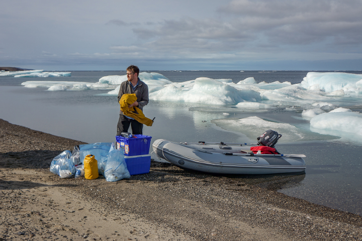 “When we were sampling the water in this region, we found this ice barrier to be a bit more of a problem to navigate in our small inflatable boats, but ice along the shore did make it simple to sample sea ice. This image shows Greg Lehn preparing to launch our boat.”