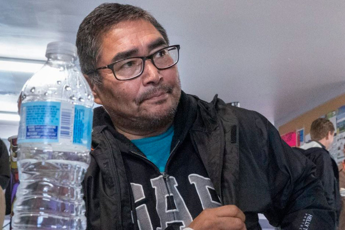 A water bottle sits on the table in front of Chief and NDP candidate Rudy Turtle during a visit by NDP Leader Jagmeet Singh on Oct. 5, 2019 on the Grassy Narrows First Nation, where industrial mercury poisoning in its water system has seriously affected the health of the community. // THE CANADIAN PRESS/Paul Chiasson